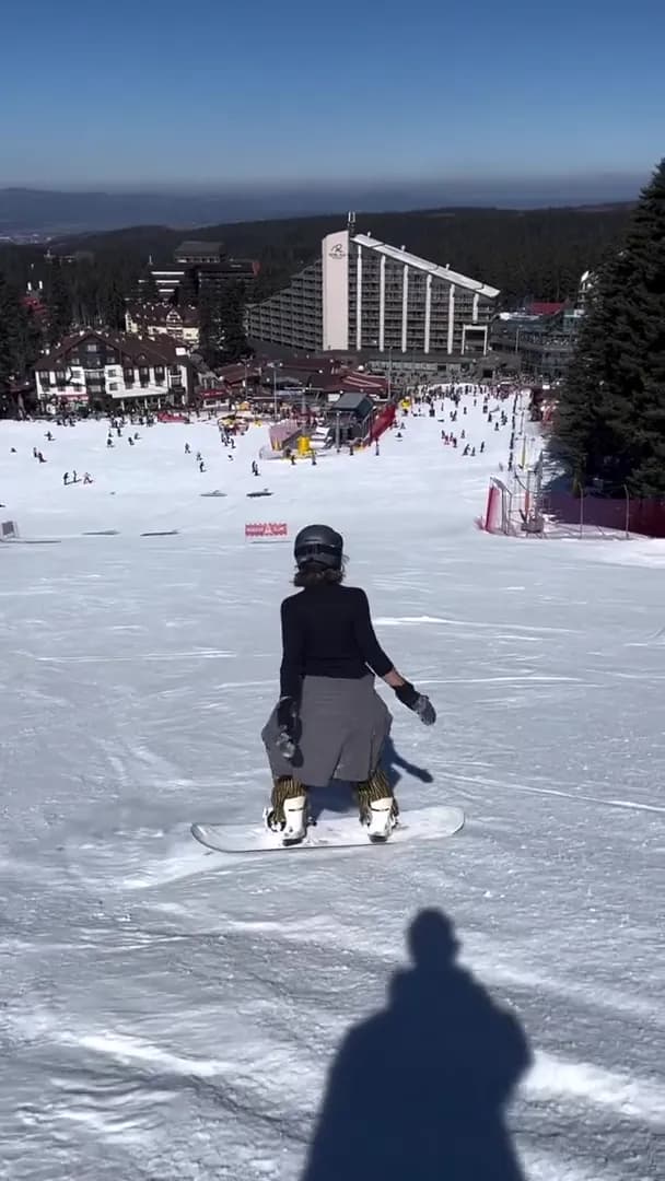 Snowboarder heading down on Popangelov slope doing long turns
