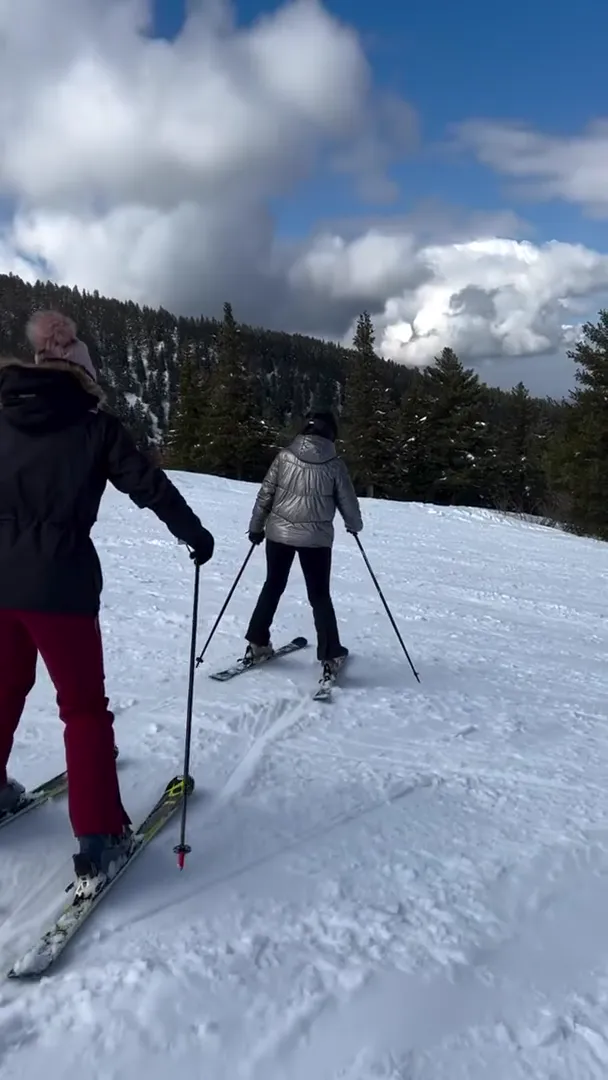 Two skiers practice their ski style called 'pizza'