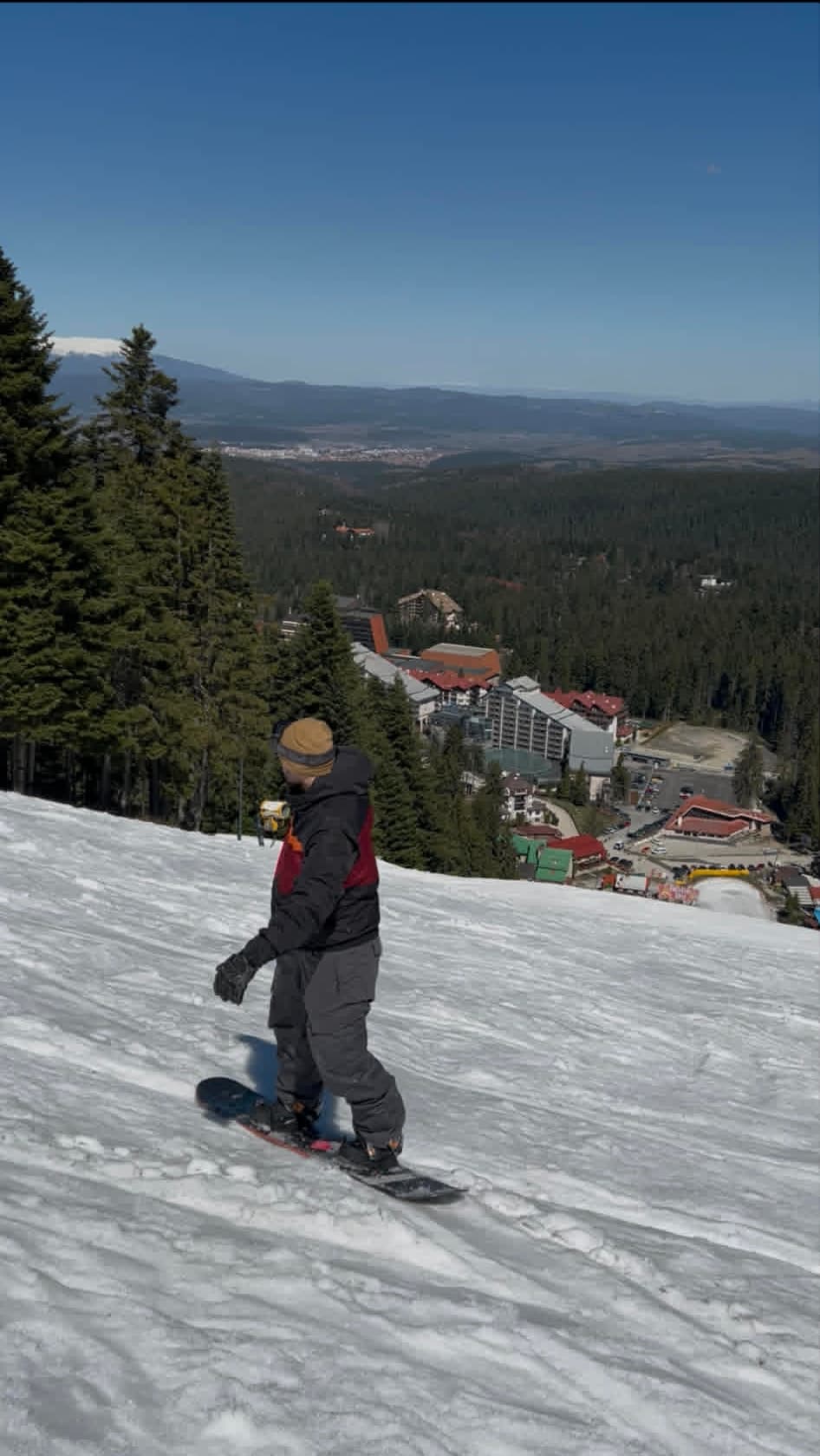 Snowboarder mid-carve on a steep red run