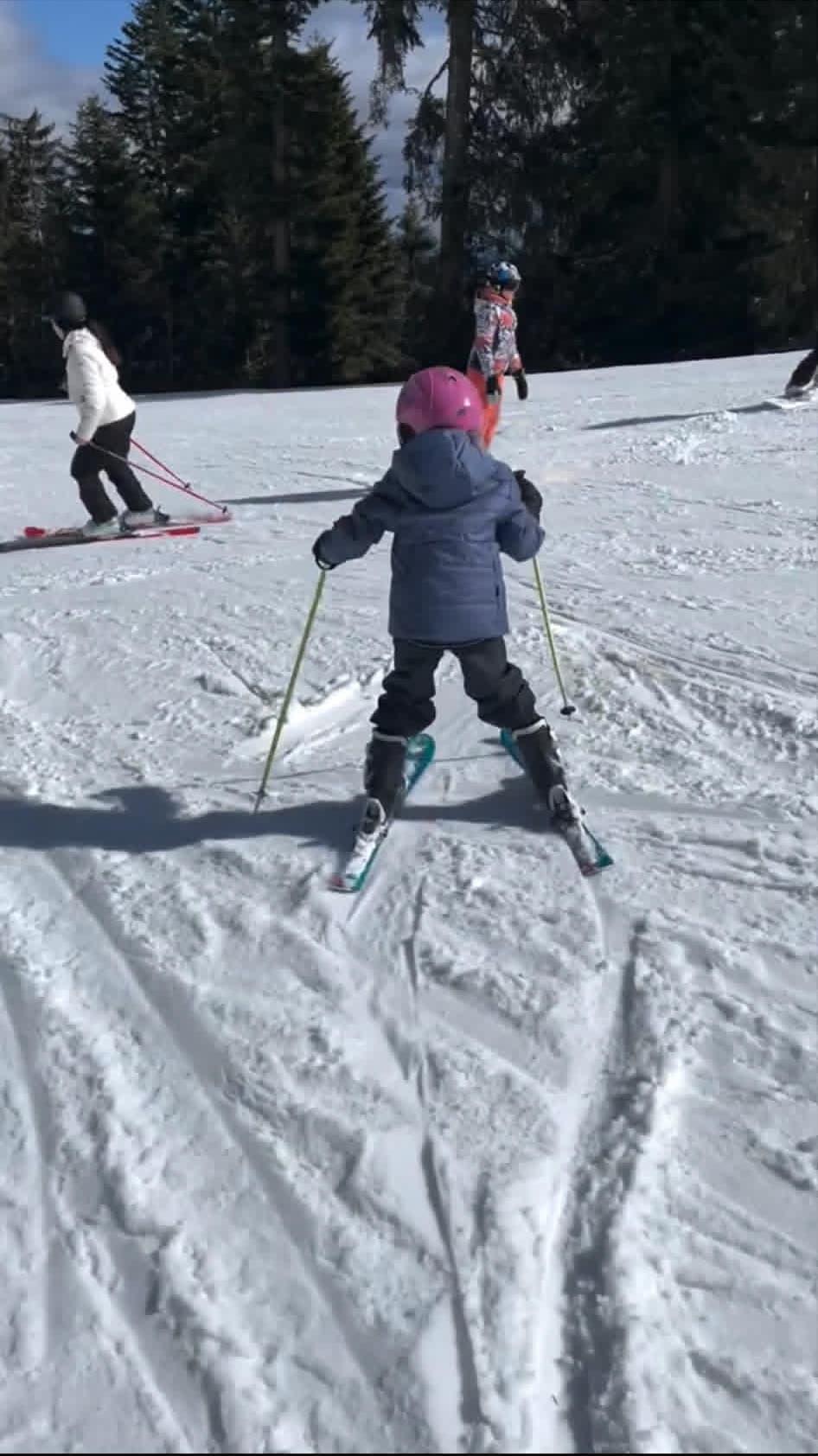 Child holding snowplow on blue slope